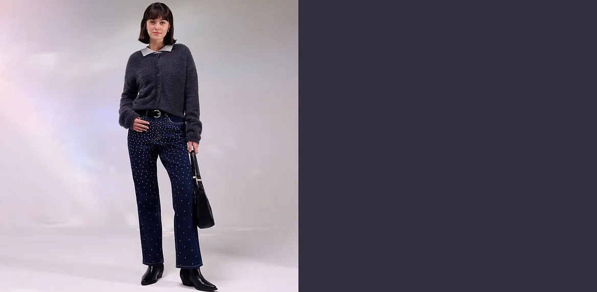 Mörk jacka, jeans med strass och matchande väska.