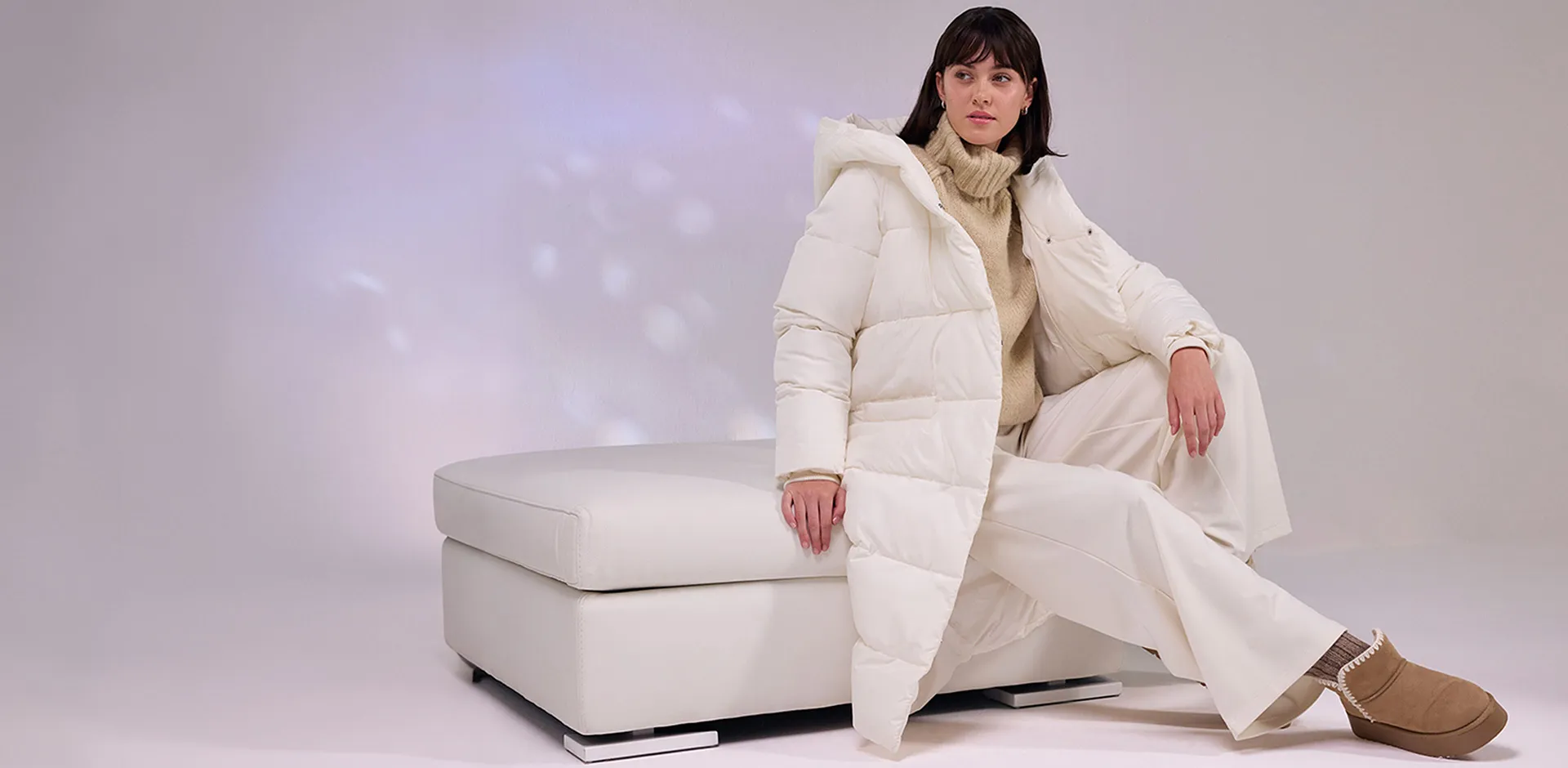 Krämfärgad dunjacka, vita byxor och fluffiga boots.