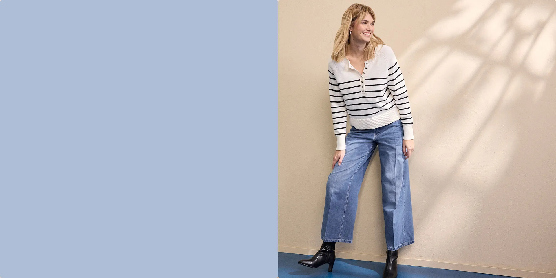 Randig vit tröja med dragkedja, i kombination med vida jeans och svarta stövlar.