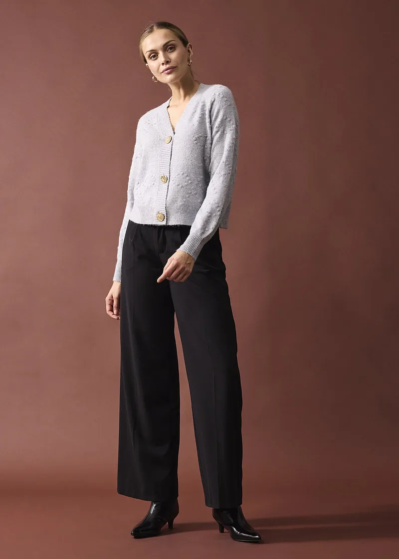 Elegant vit cardigan med stora knappar.