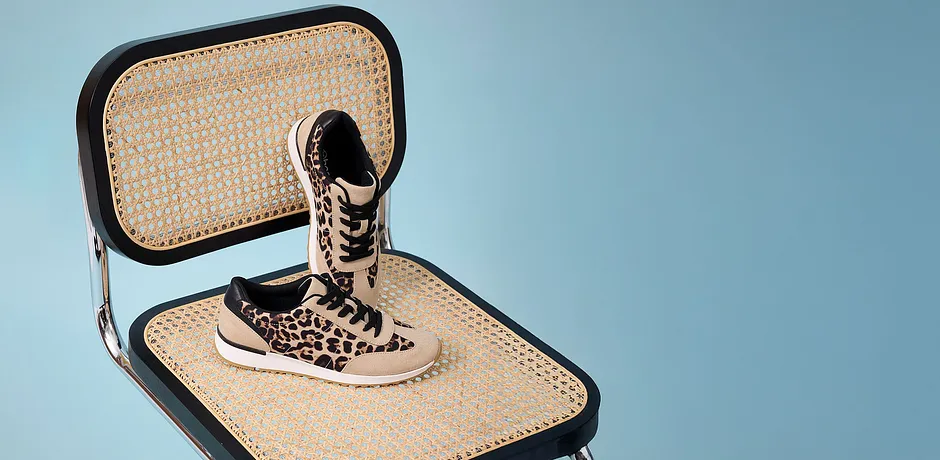 Stilsäkra sneakers med leopardmönster på en flätad stolsits.