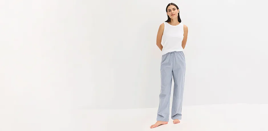 Ledig pyjamaslook: vitt linne kombinerat med randig, luftig byxa för en avspänd elegans.