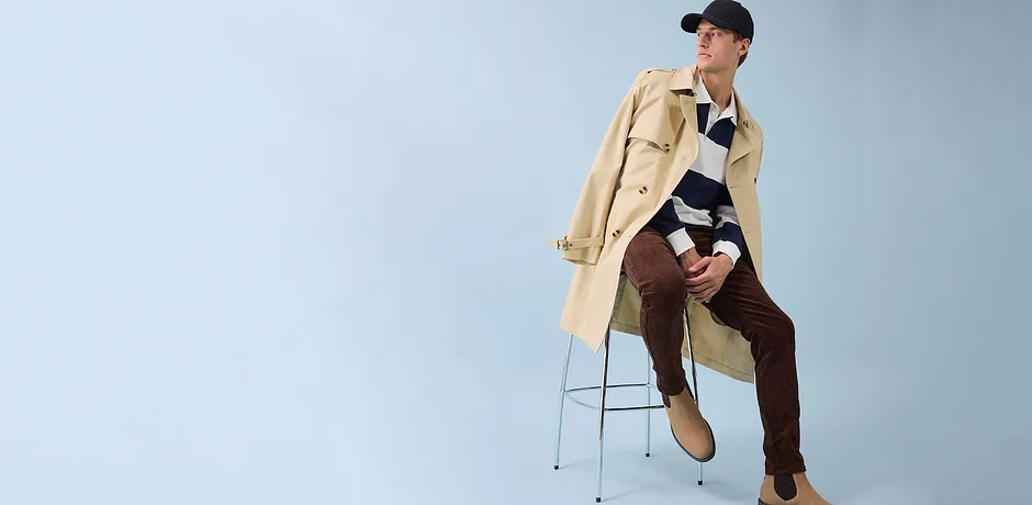 Stilfull trenchcoat, bruna byxor och svart keps - en modern look för vardagen.