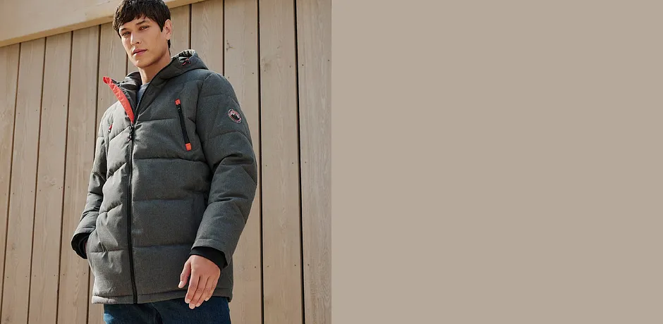 Varm grå vinterjacka med huva samt jeans.