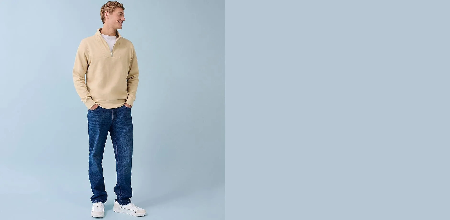 Beige tr&ouml;ja med dragkedja, bl&aring;a jeans och vita sneakers - en ledig vardagslook f&ouml;r m&auml;n.