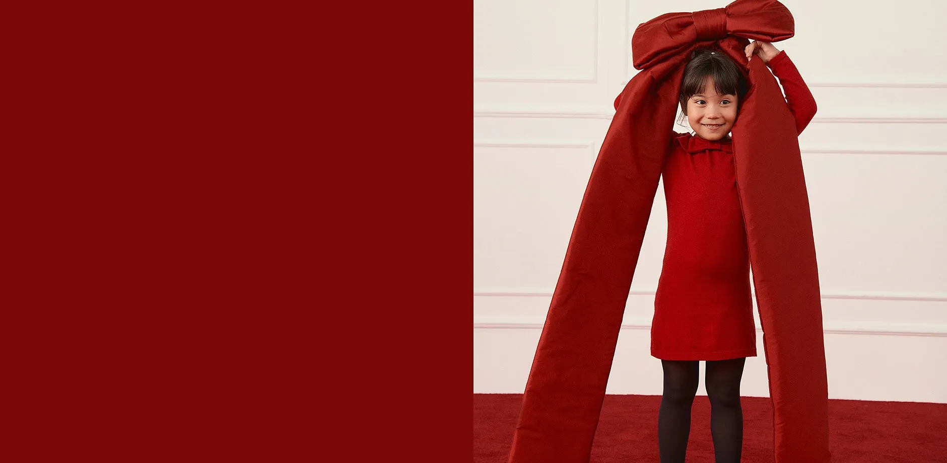 En röd klänning med svarta strumpbyxor.