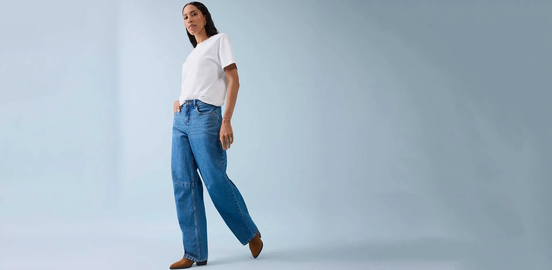 Klassisk vit T-shirt kombinerad med vida jeans och bruna skor.