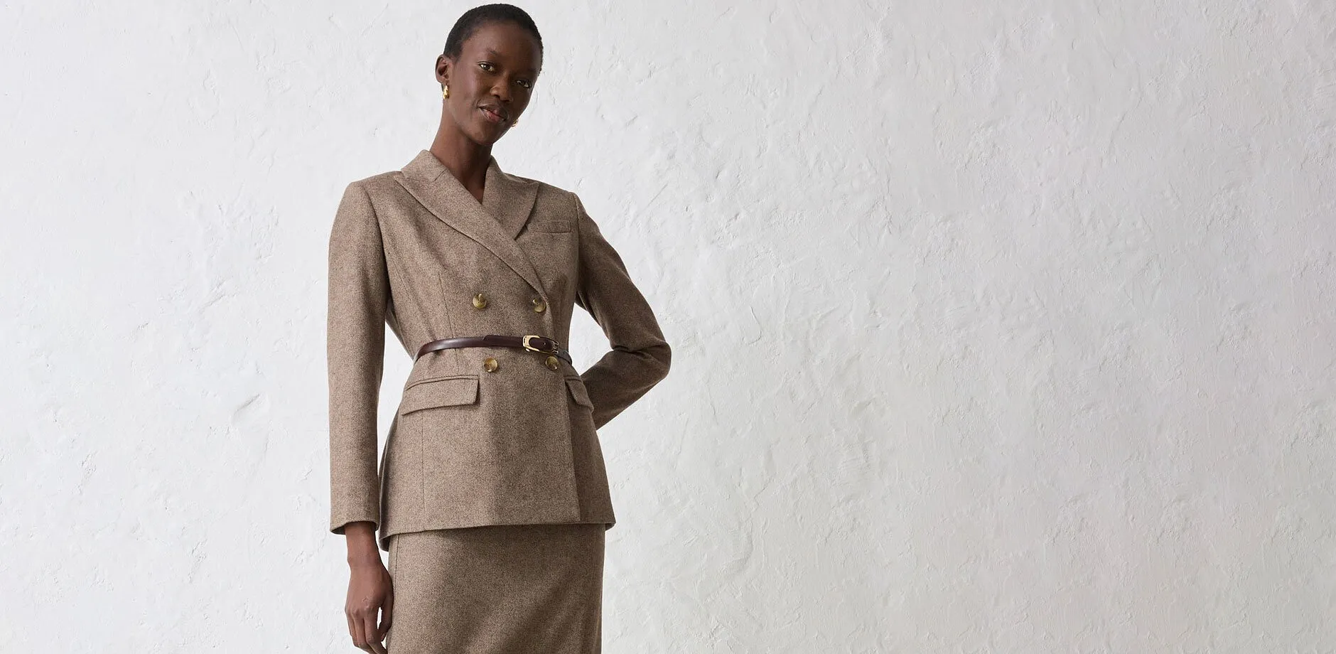 Beige kavaj med bälte, kombinerat med matchande kjol.

