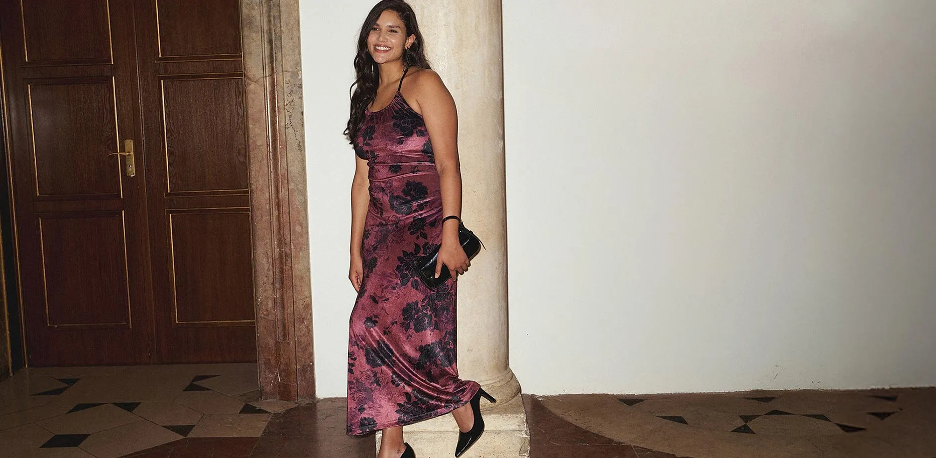 L&aring;ng kl&auml;nning med livfullt blomm&ouml;nster i lila och rosa toner.

