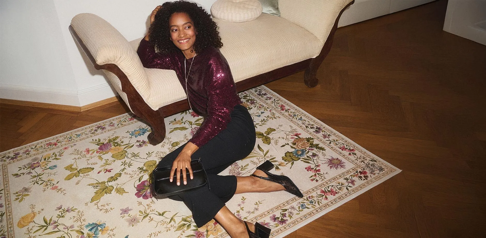 Elegant l&aring;ng&auml;rmad tr&ouml;ja i vinr&ouml;tt &ouml;ver m&ouml;rka jeans.

