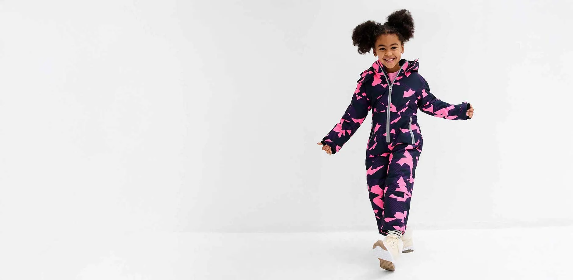 Liten flicka i vinteroverall.

