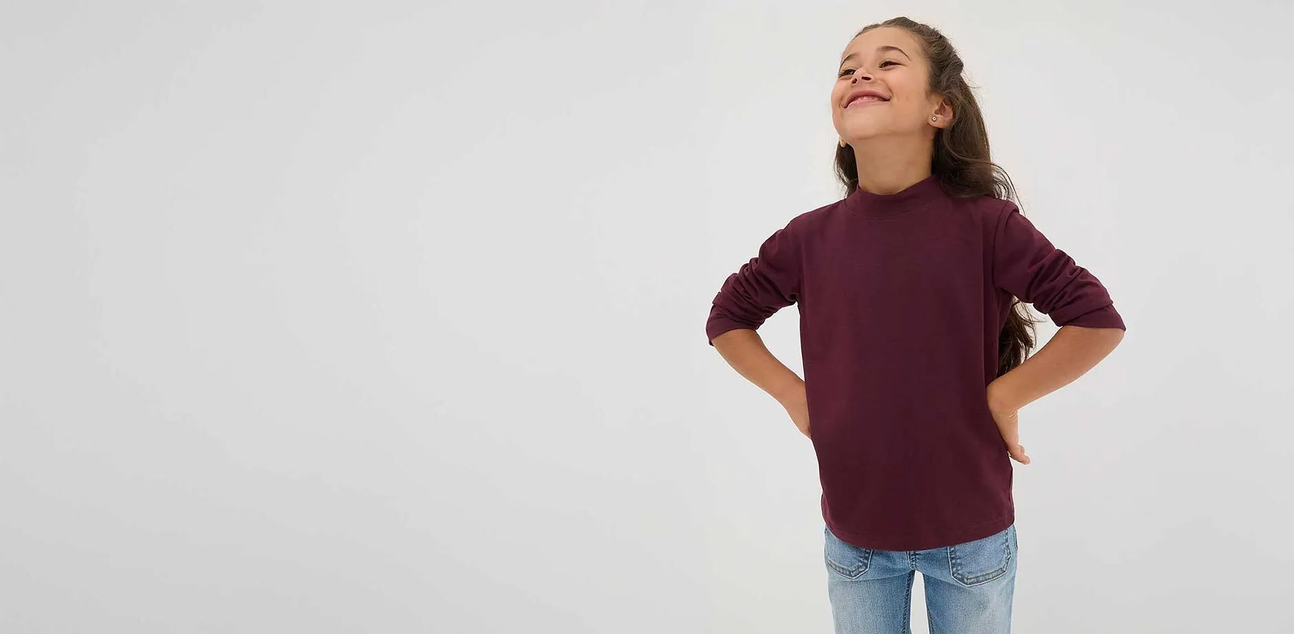 Flicka b&auml;r r&ouml;d l&aring;ng&auml;rmad tr&ouml;ja.

