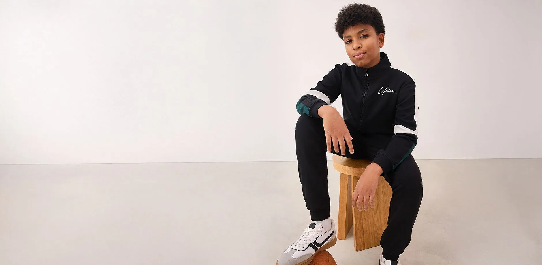 Bl&aring; jacka med vit logga, lediga jeans och sneakers.

