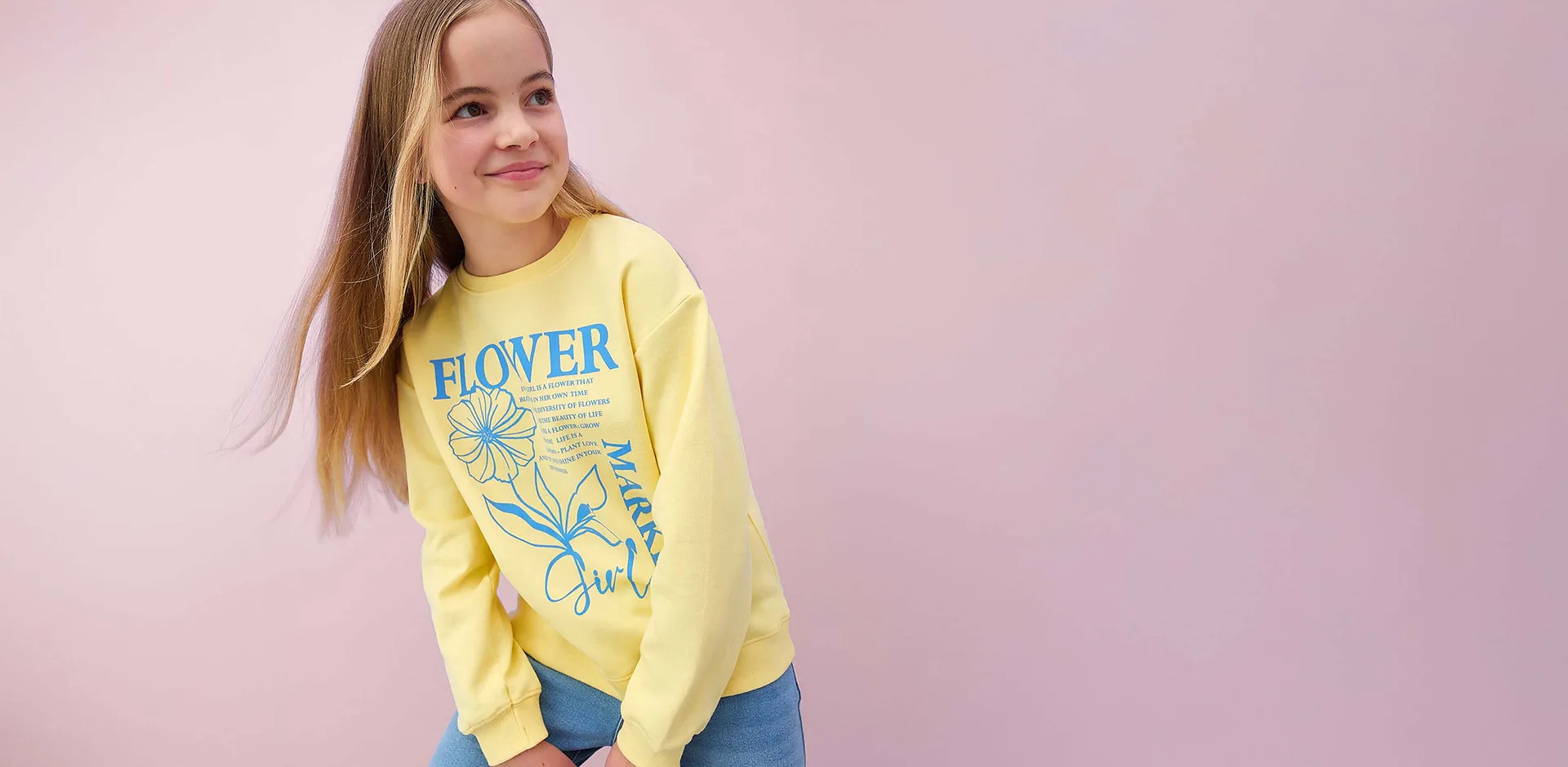 Gul l&aring;ng&auml;rmad tr&ouml;ja med blommigt m&ouml;nster och text.

