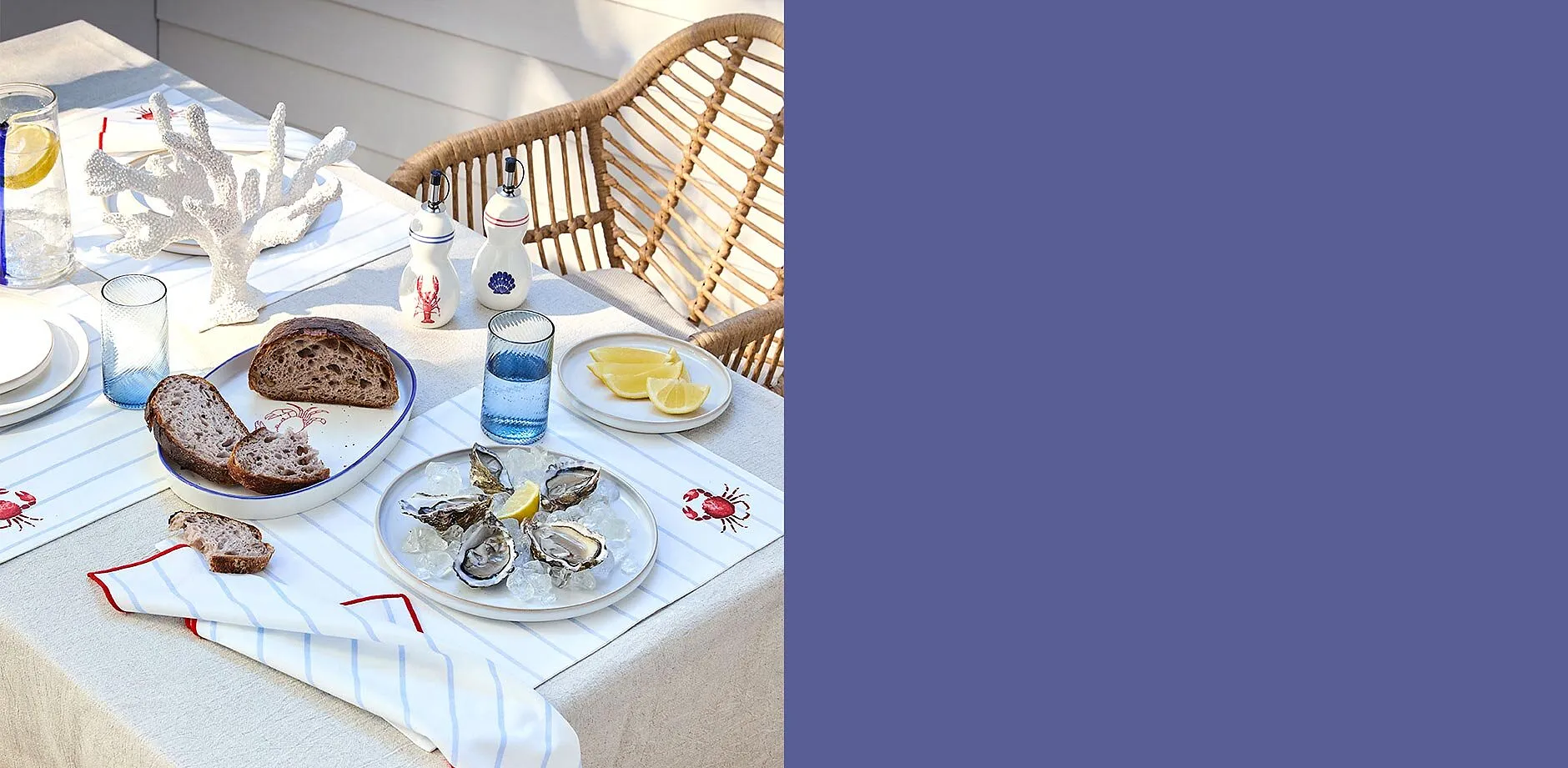 Elegant vit duk med r&ouml;tt broderi pryder det somriga picknickbordet utomhus.