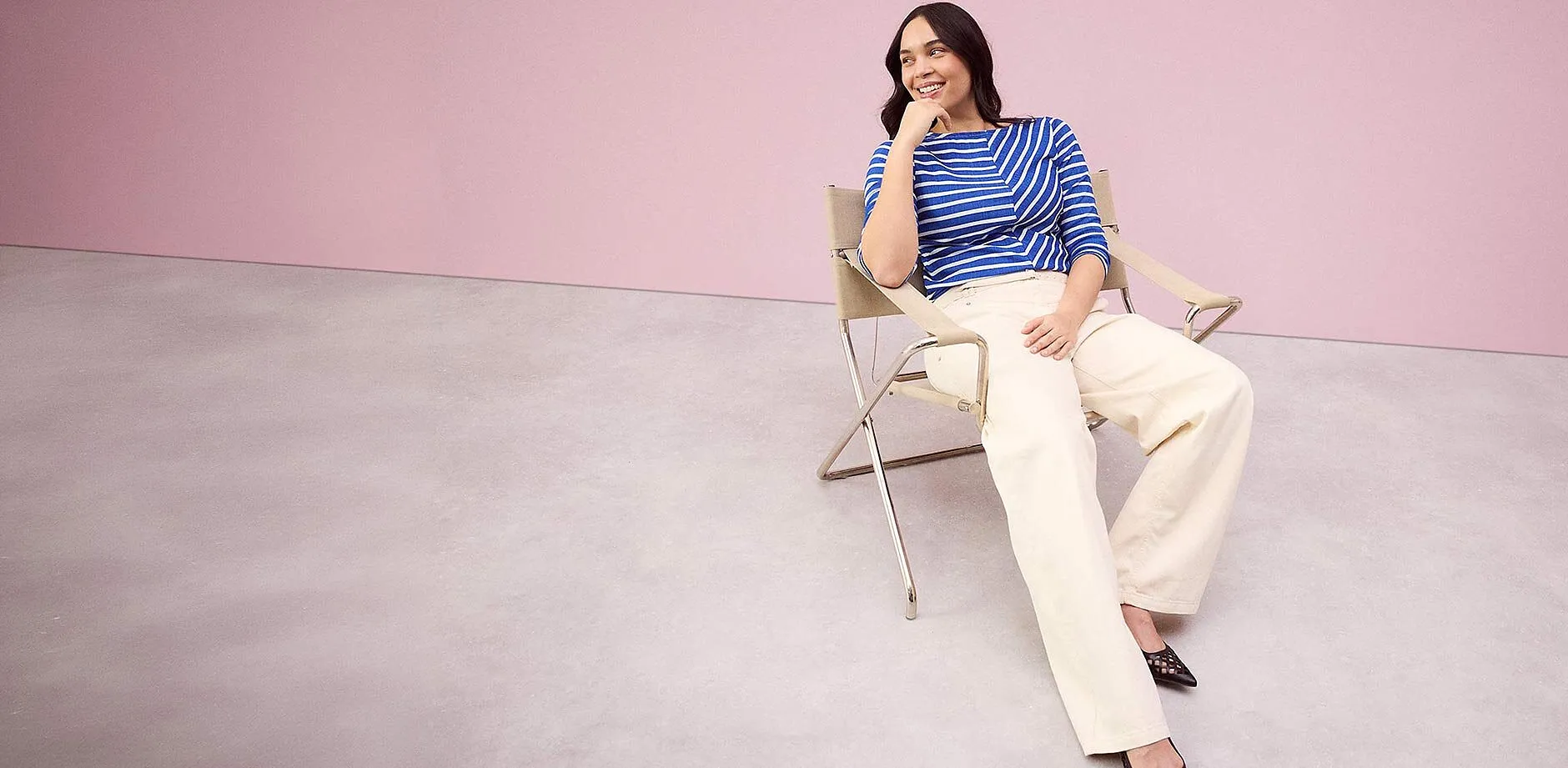 En randig, bl&aring;vit &ouml;verdel kombinerad med en vid, cremef&auml;rgad byxa.