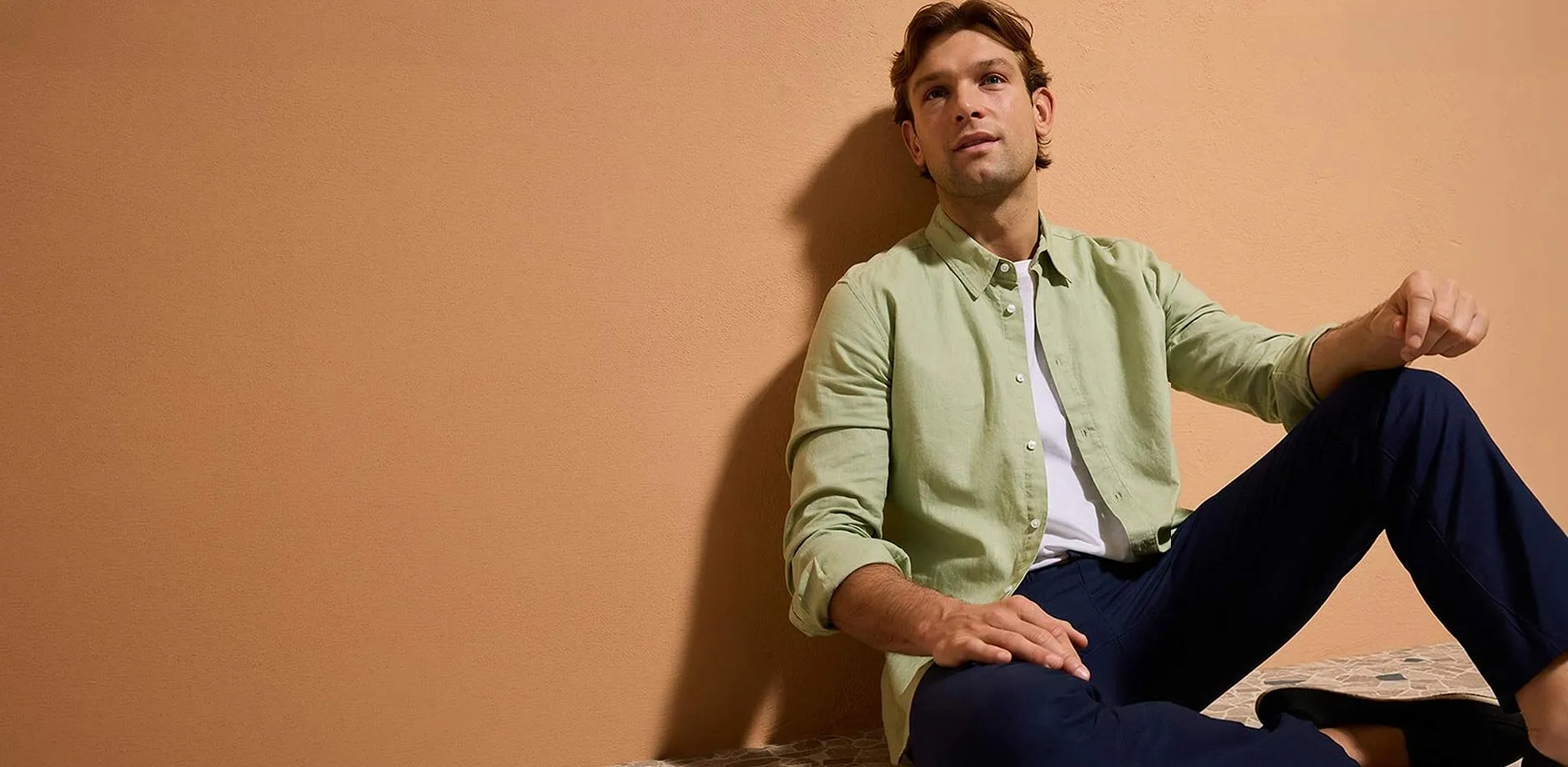 Pastellgr&ouml;n skjorta, m&ouml;rkbl&aring; byxor och lediga skor.

