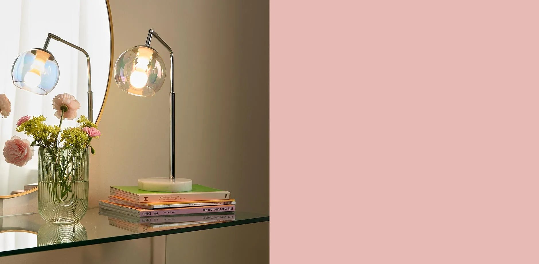 Elegant bordslampa med glassk&auml;rm belyser stilfullt det moderna vardagsrummet med varma f&auml;rgtoner.

