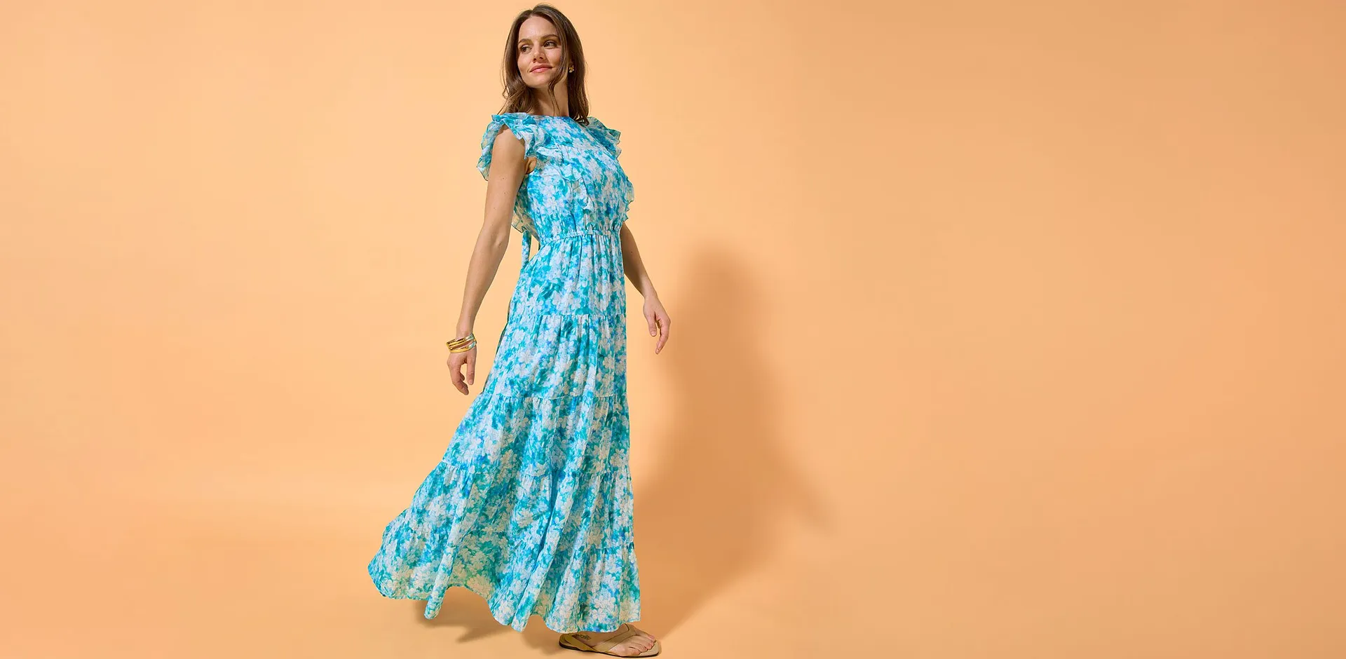 Bl&aring; maxikl&auml;nning med tropiskt blomm&ouml;nster.