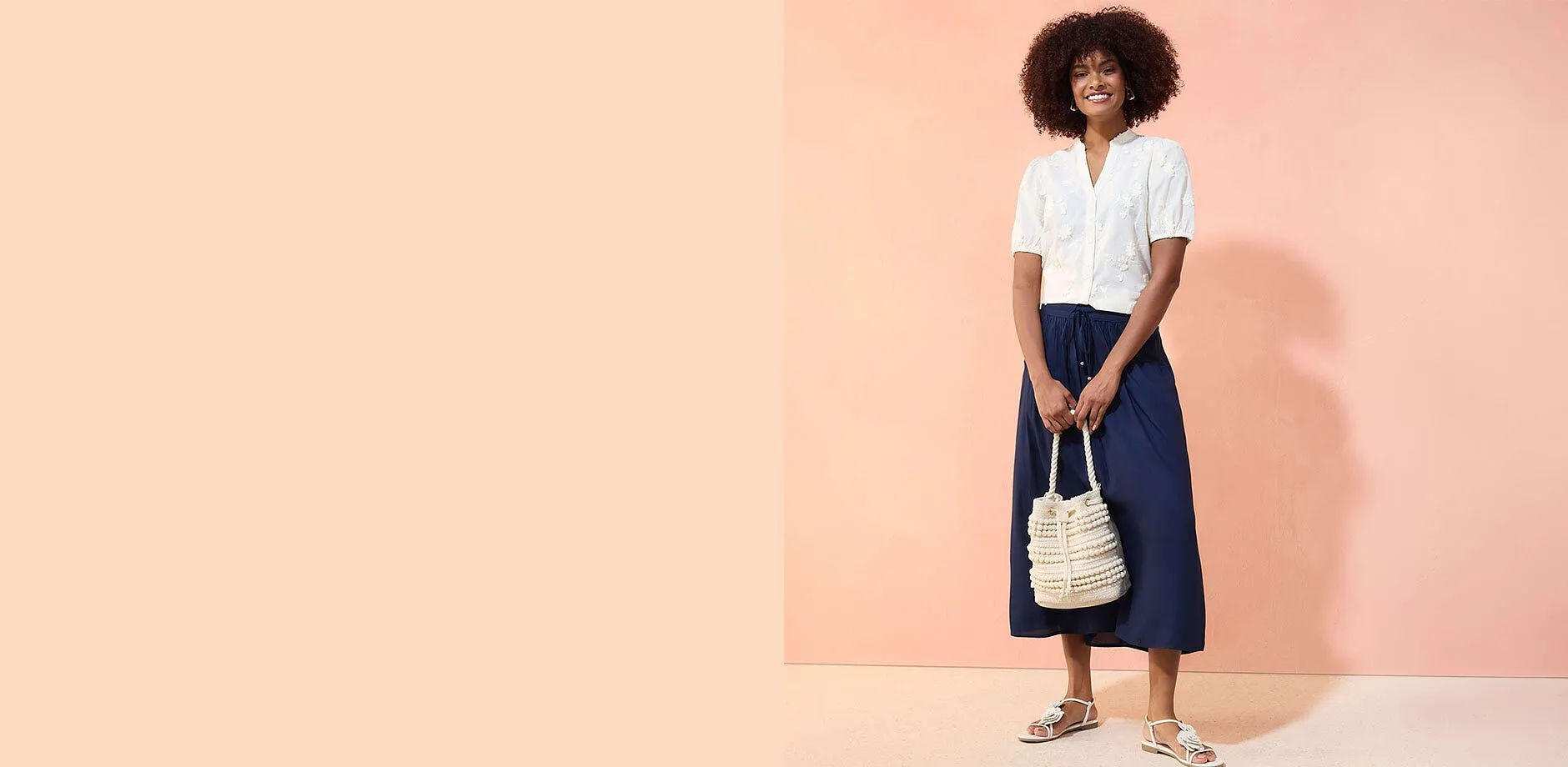 En vit blus och marinbl&aring; kjol skapar en elegant, avslappnad look.

