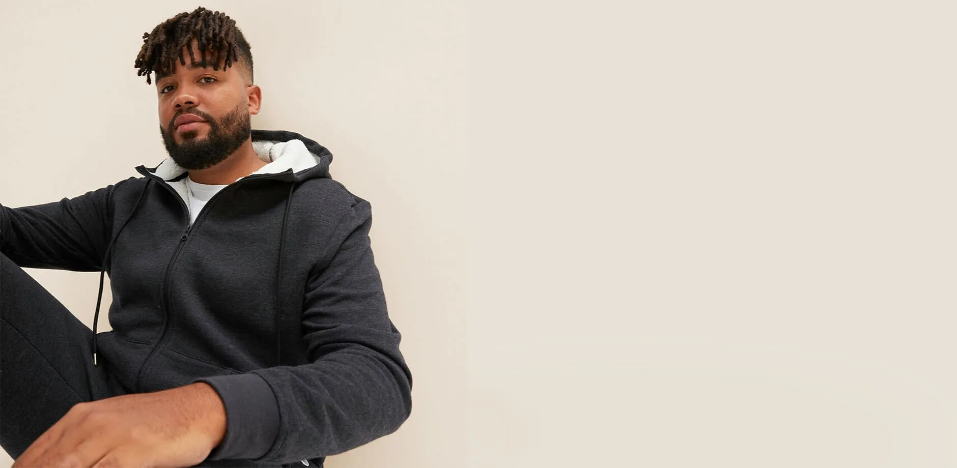 En m&ouml;rkgr&aring; huvjacka med vitt foder.

