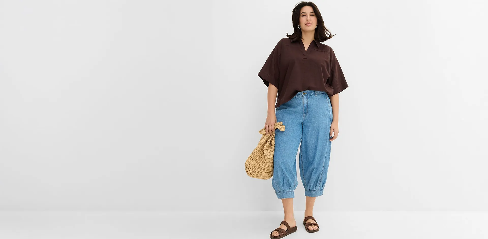 Kombination av brun blus och vida jeans med sandaler och str&aring;v&auml;ska.


