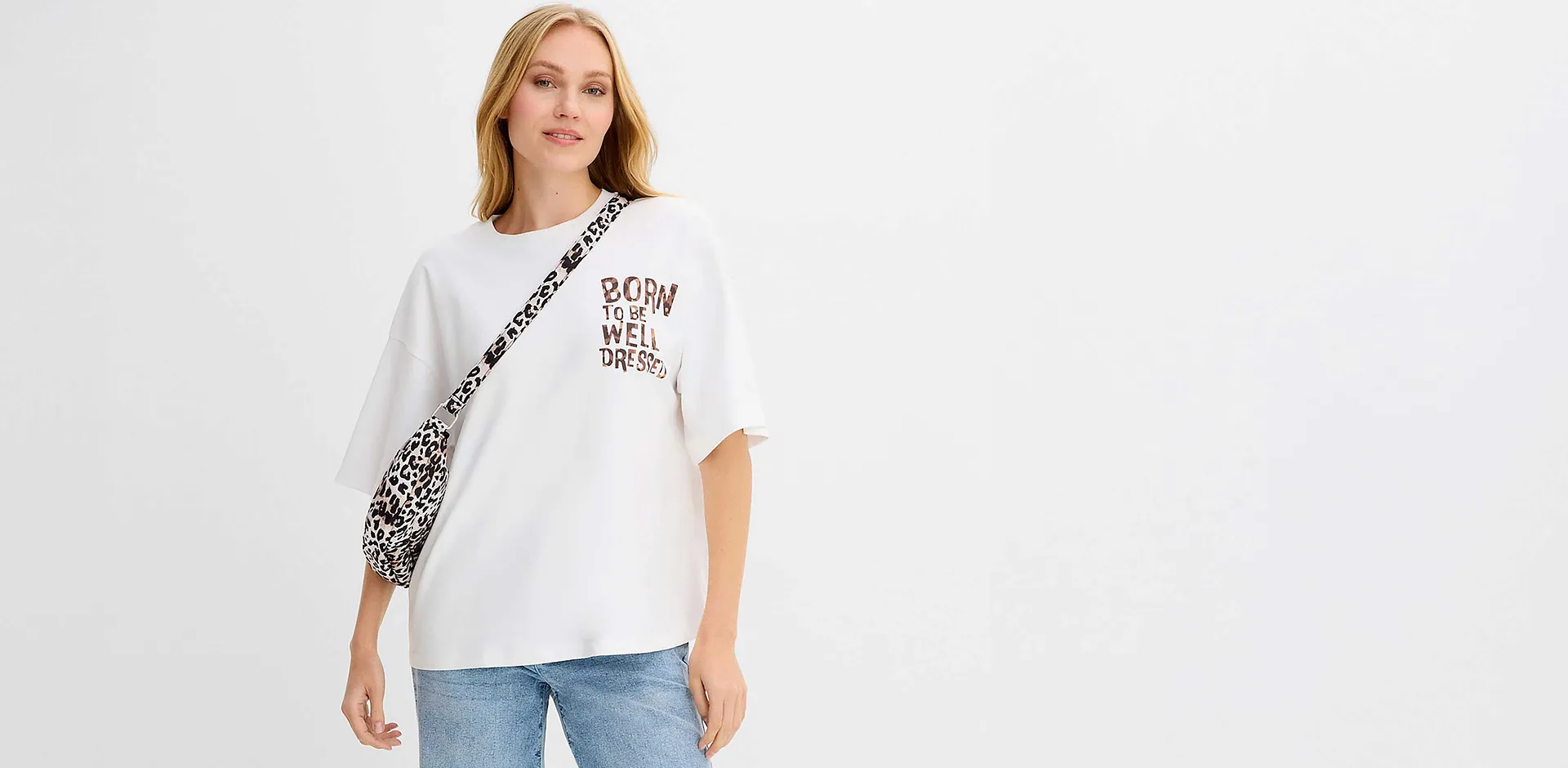 Vitt T-shirt med tryck och leopardm&ouml;nsterdetaljer kombinerat med avslappnade bl&aring; jeans.

