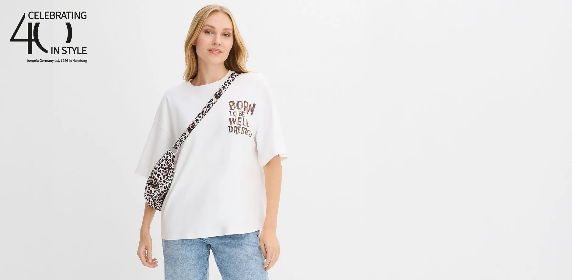 Vitt T-shirt med tryck och leopardm&ouml;nsterdetaljer kombinerat med avslappnade bl&aring; jeans.

