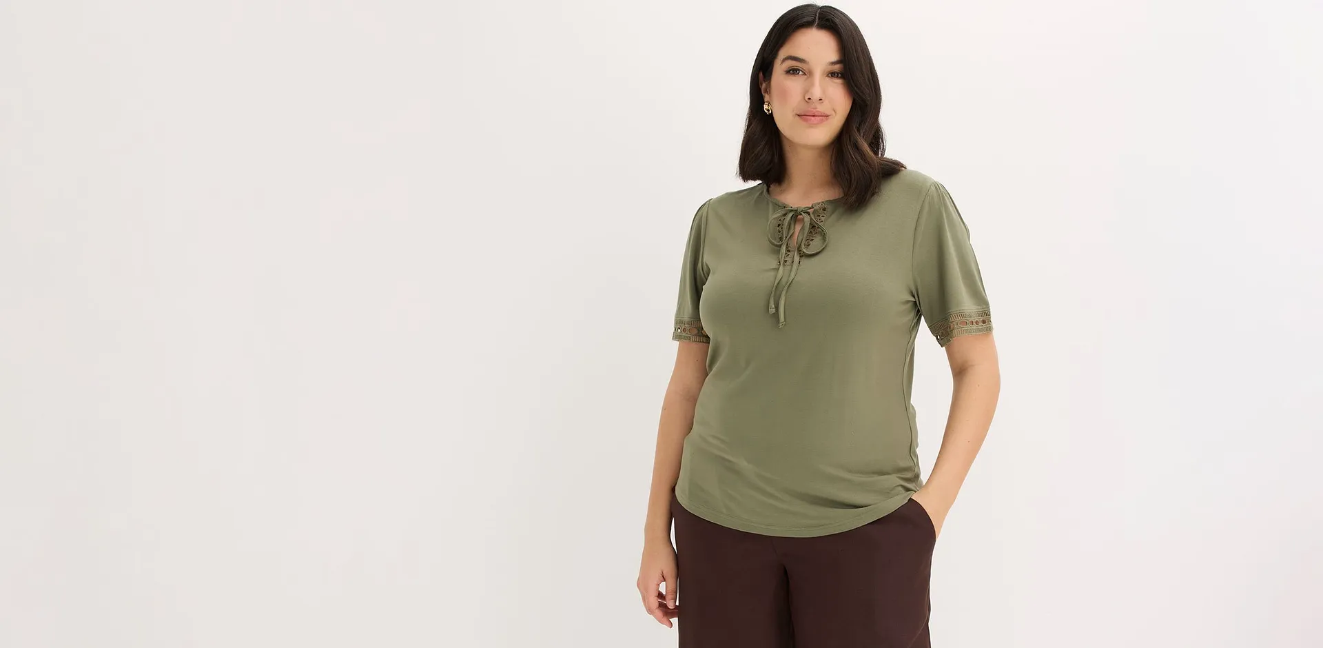 Olivgr&ouml;n T-shirt kombinerad med bruna byxor.

