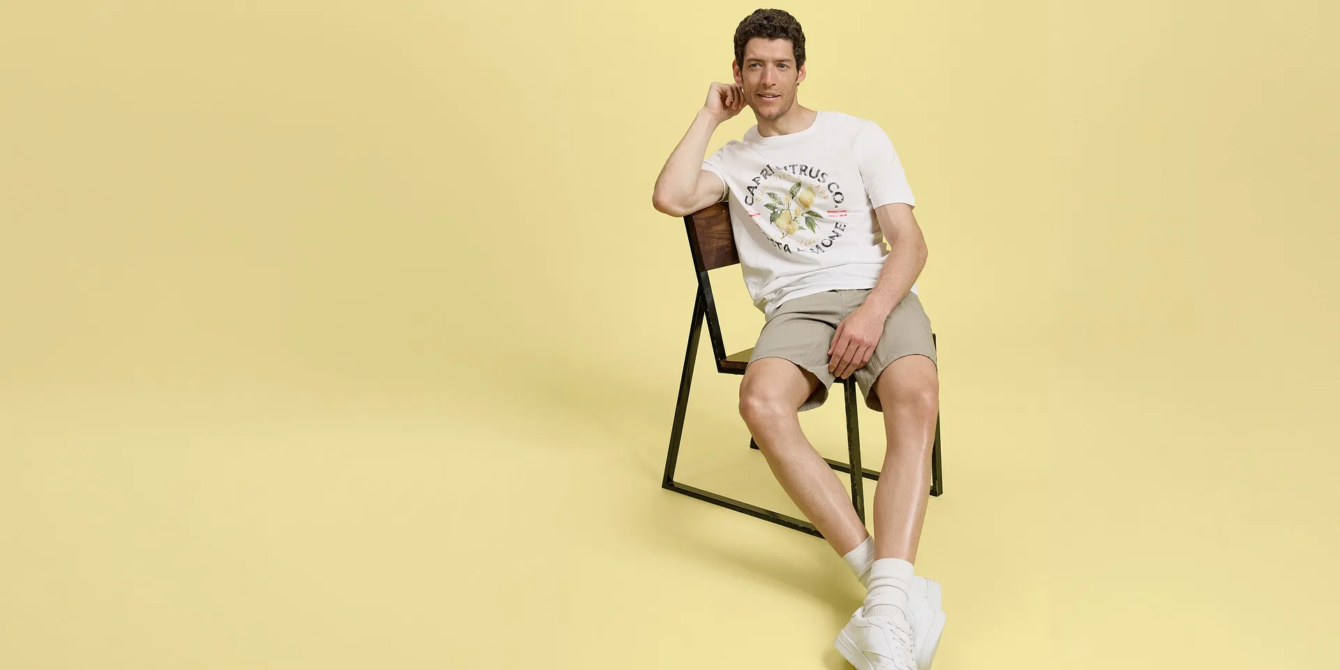 Sommarlook med beige shorts, vit T-shirt och bekv&auml;ma sneakers.

