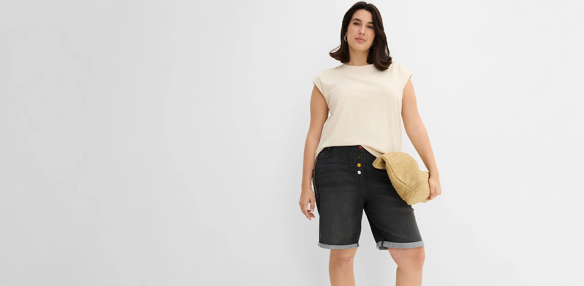 Beige topp och m&ouml;rka jeansbermudas med uppvikta benslut.


