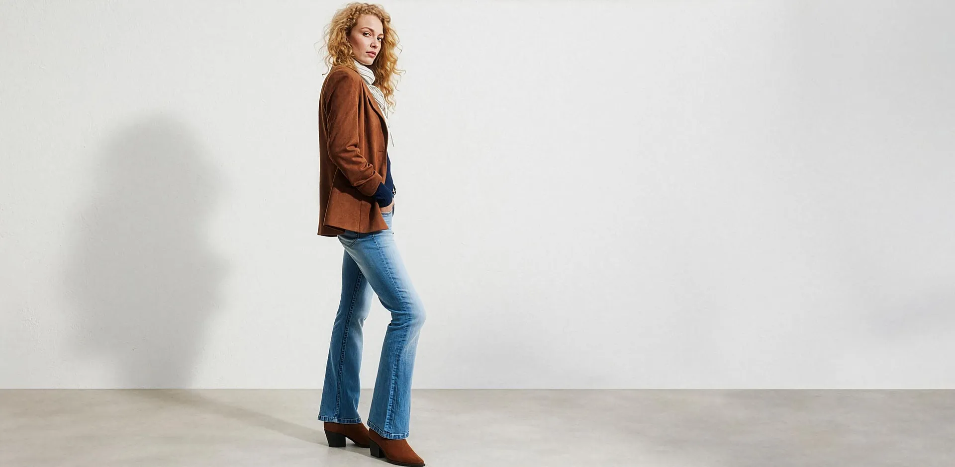 Brun mockajacka, lediga, utsv&auml;ngda jeans, vit polokrage och bruna st&ouml;vletter.