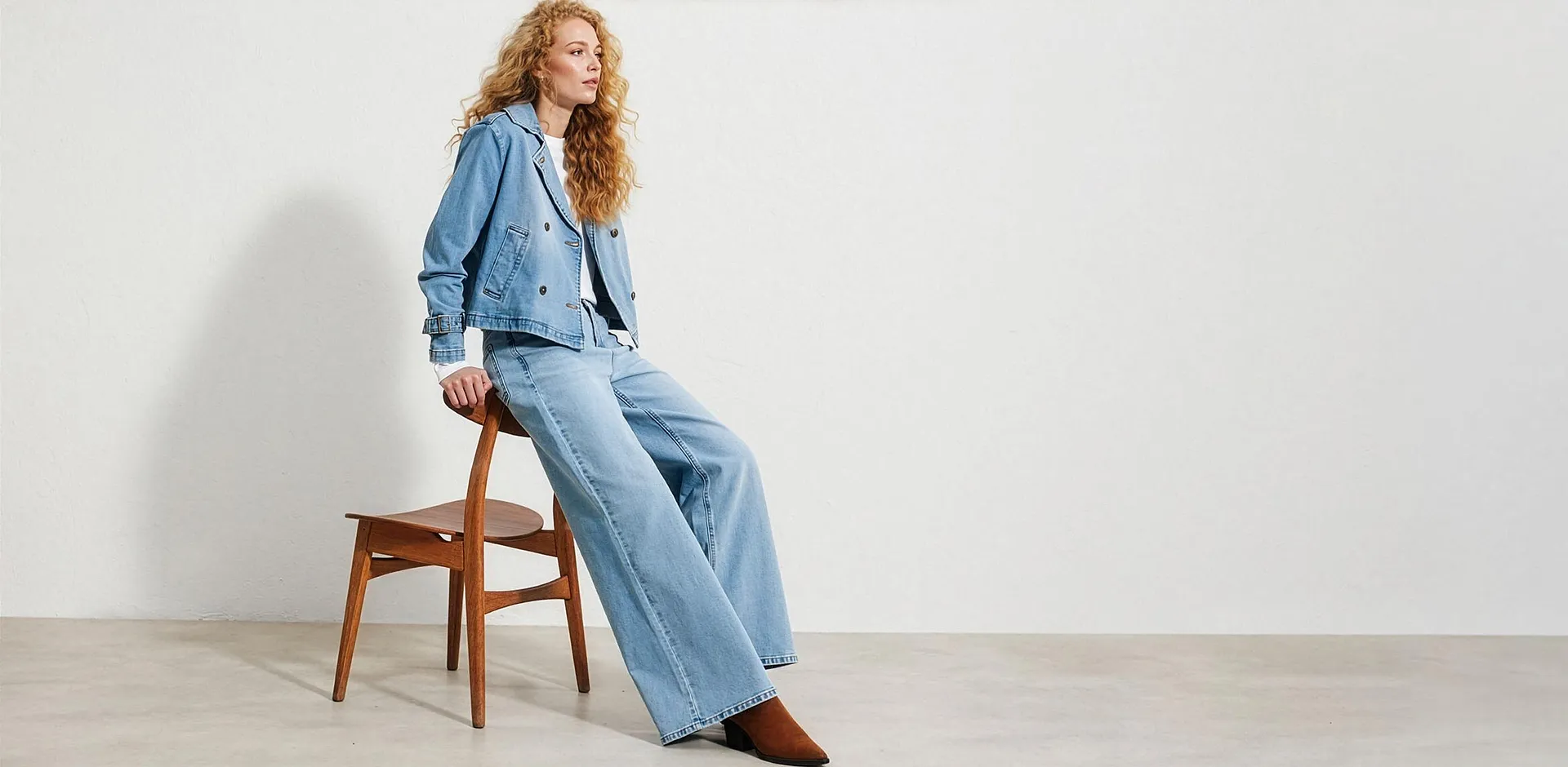 Kurze hellblaue Jeansjacke, weite Hose und wei&szlig;es Shirt.