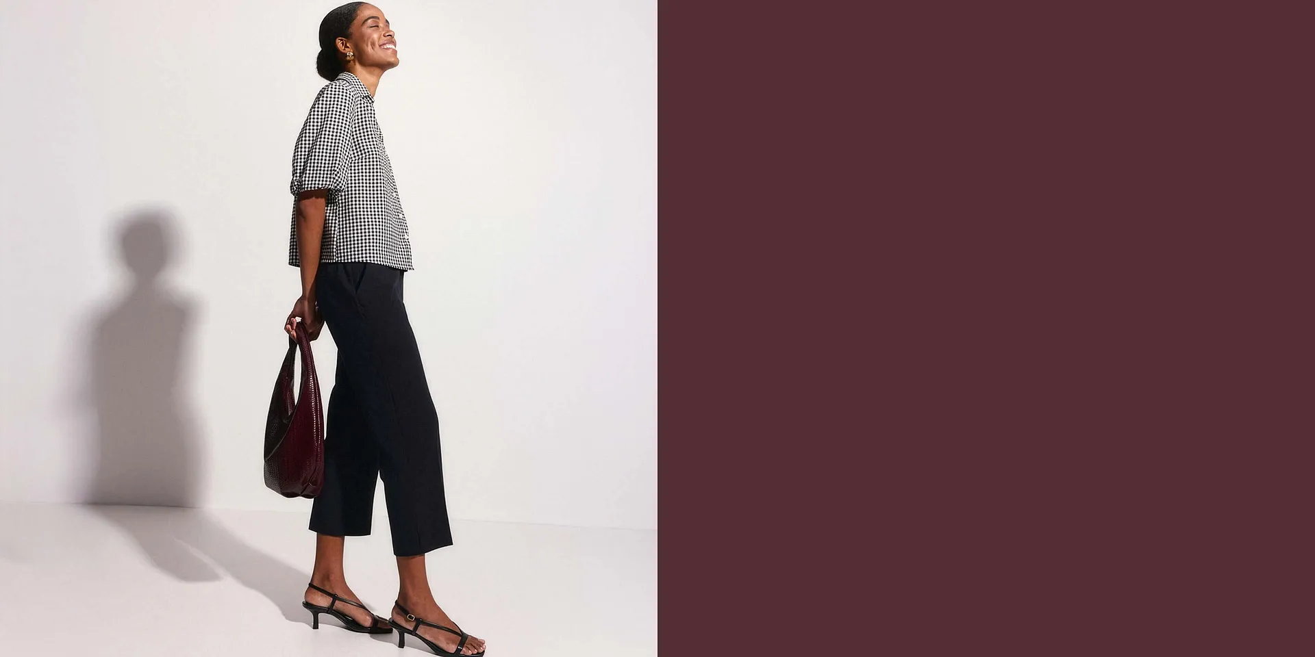 Elegant kombination: rutig blus, m&ouml;rk culottebyxa och eleganta remsandaler med v&auml;ska.