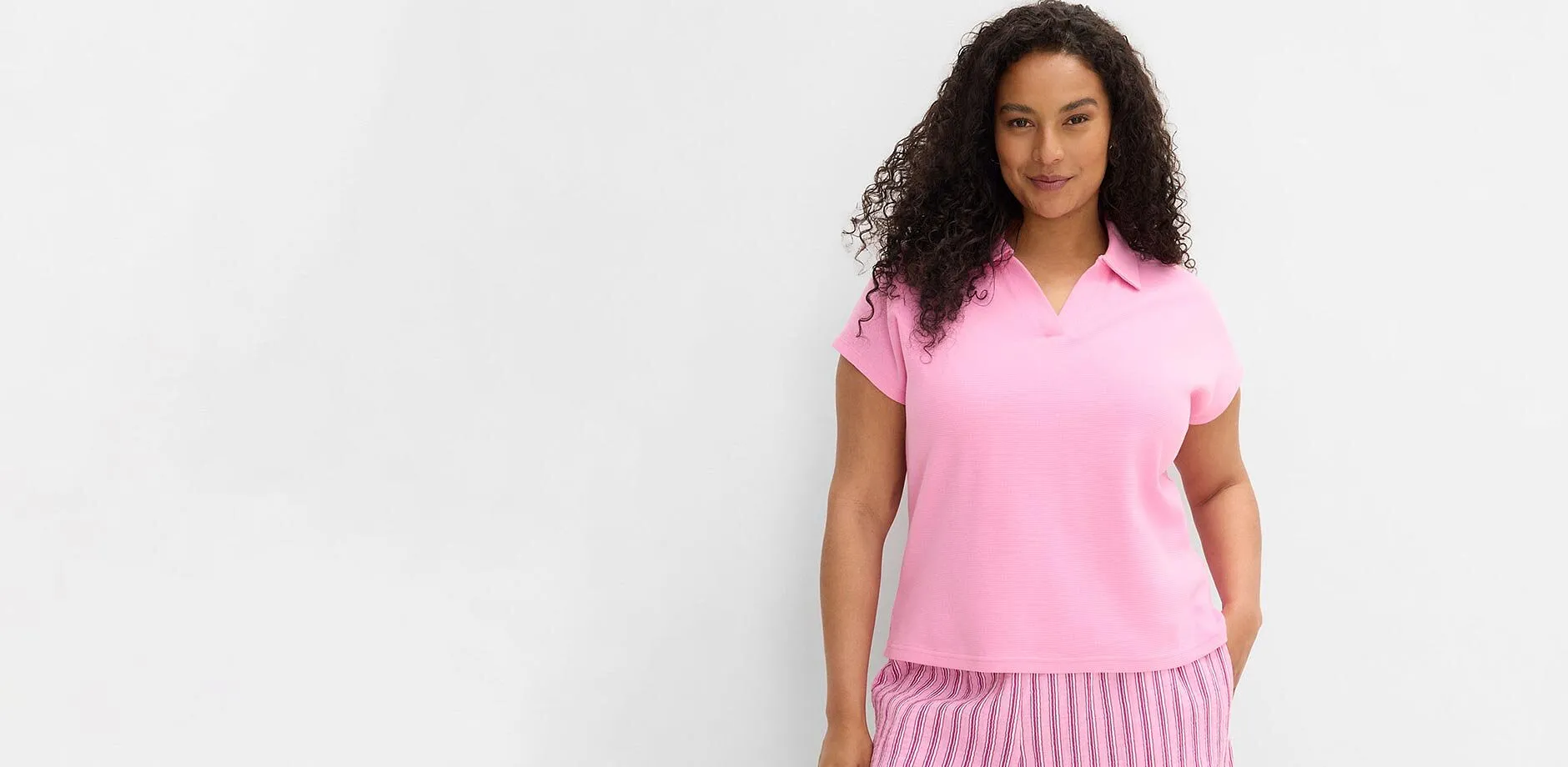 Kort&auml;rmad, rosa pik&eacute;tr&ouml;ja och en randig byxa.