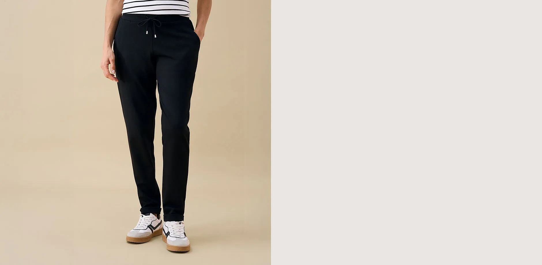 Svarta byxor, randig topp och moderna sneakers f&ouml;r en bekv&auml;m casual-look.