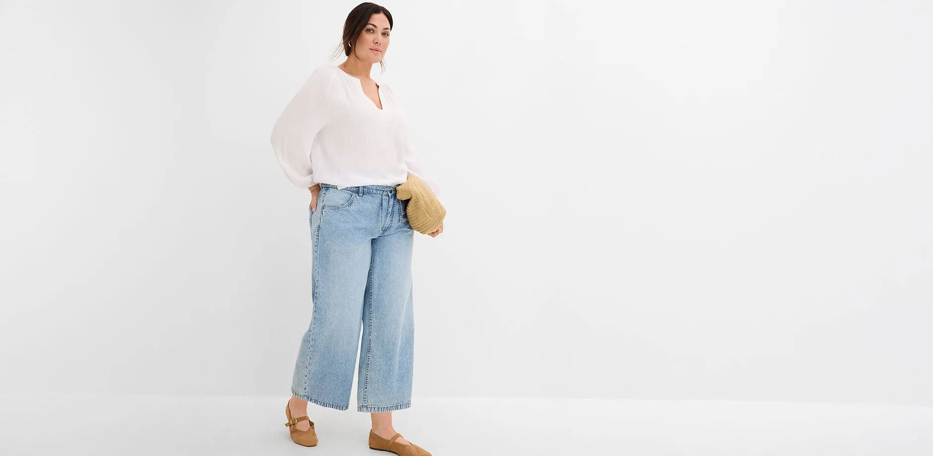 Ledig vit blus, vida jeans och till det bruna skor och fl&auml;tad v&auml;ska.