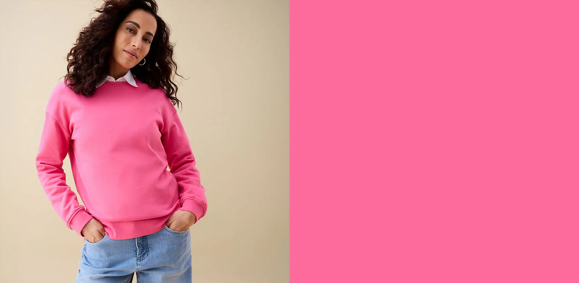 Rosa sweatshirt &ouml;ver en vit skjorta kombinerat med lediga bl&aring; jeans.