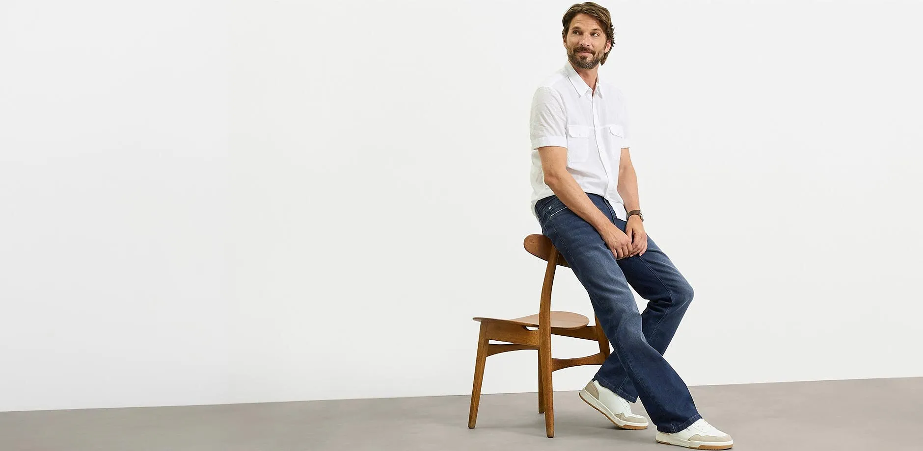 Vit, kort&auml;rmad skjorta, m&ouml;rka jeans och vita sneakers f&ouml;r en ledig look.