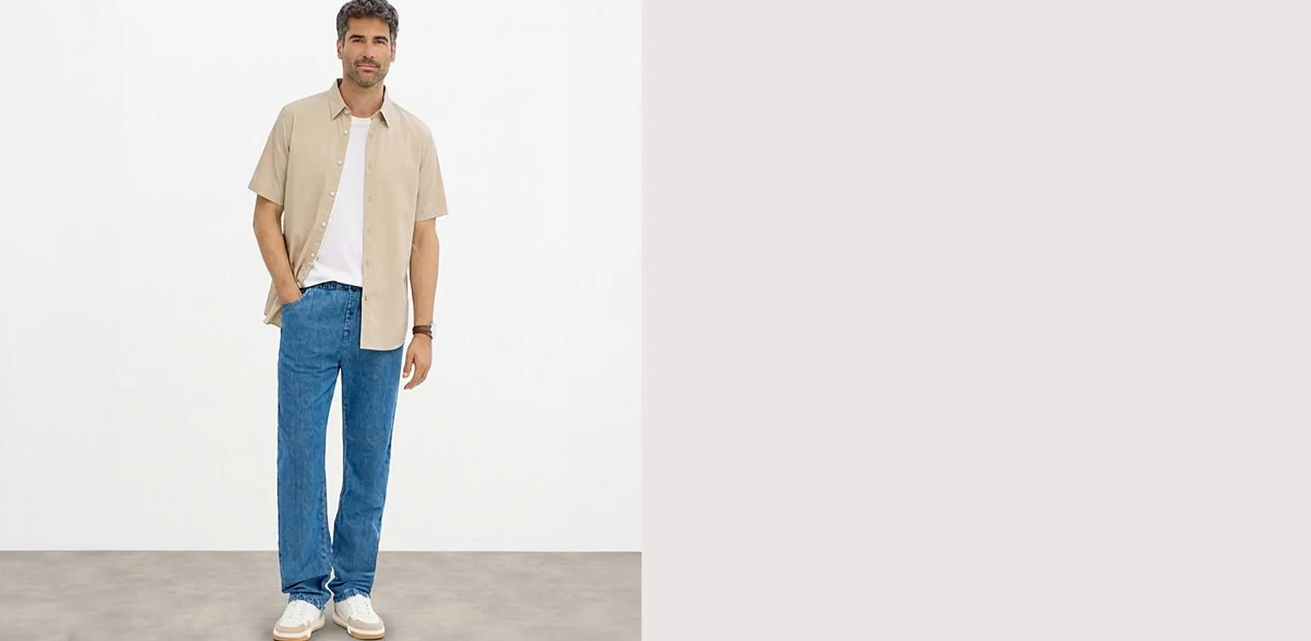 Vit t-shirt, bl&aring; jeans med klassisk passform och vita sneakers.

