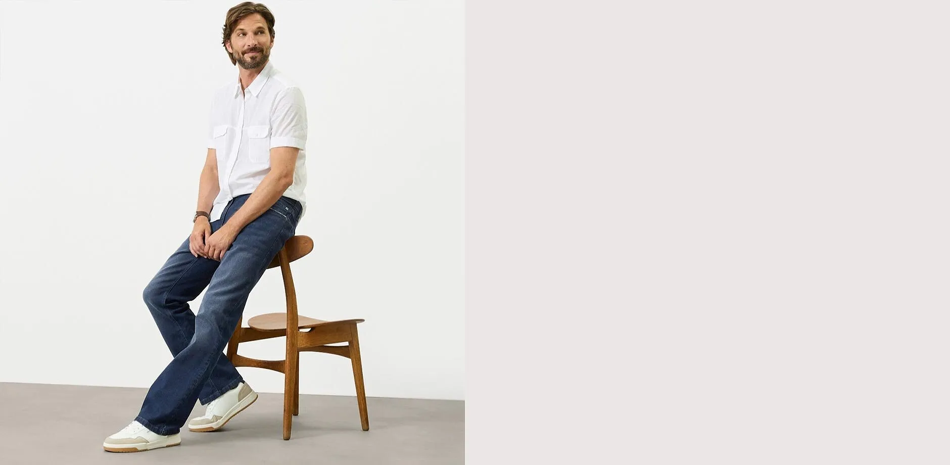 Vit t-shirt, bl&aring; jeans med normal passform och vita sneakers.

