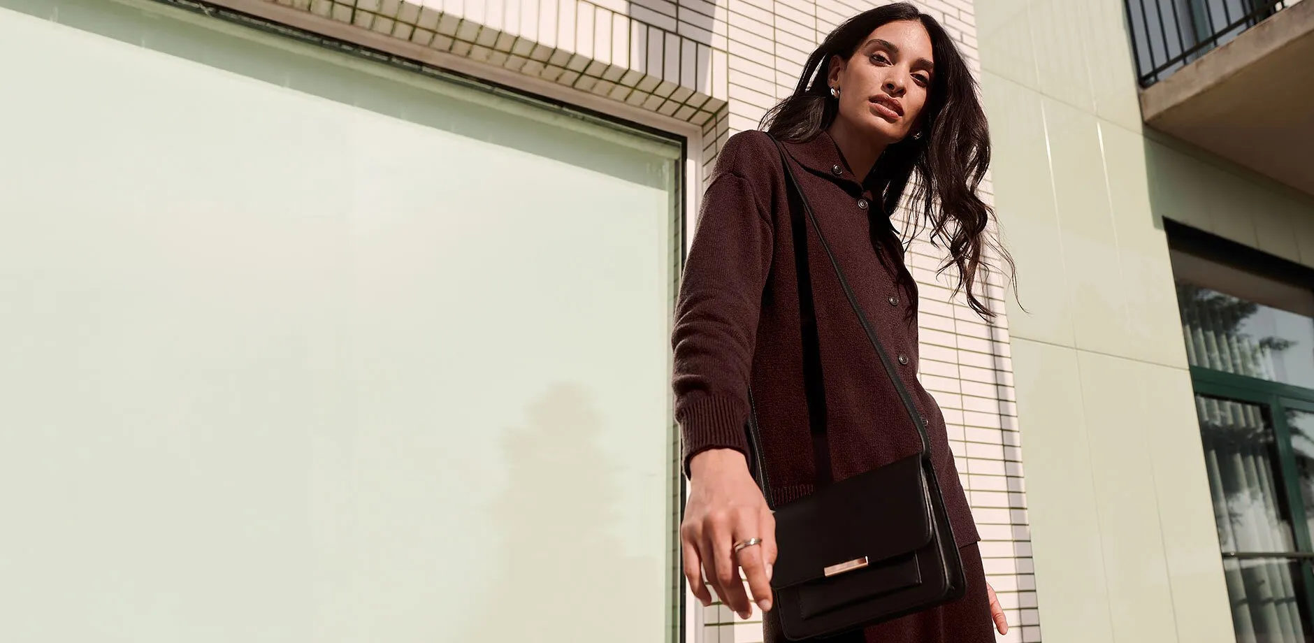 M&ouml;rk cardigan, elegant, svart v&auml;ska och diskret smycke f&ouml;r en stilfull look.