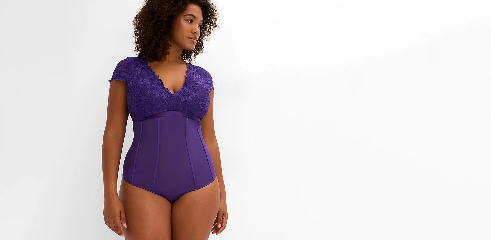 Denna f&ouml;rf&ouml;riska body i lila med spets framh&auml;ver figuren p&aring; ett elegant s&auml;tt.