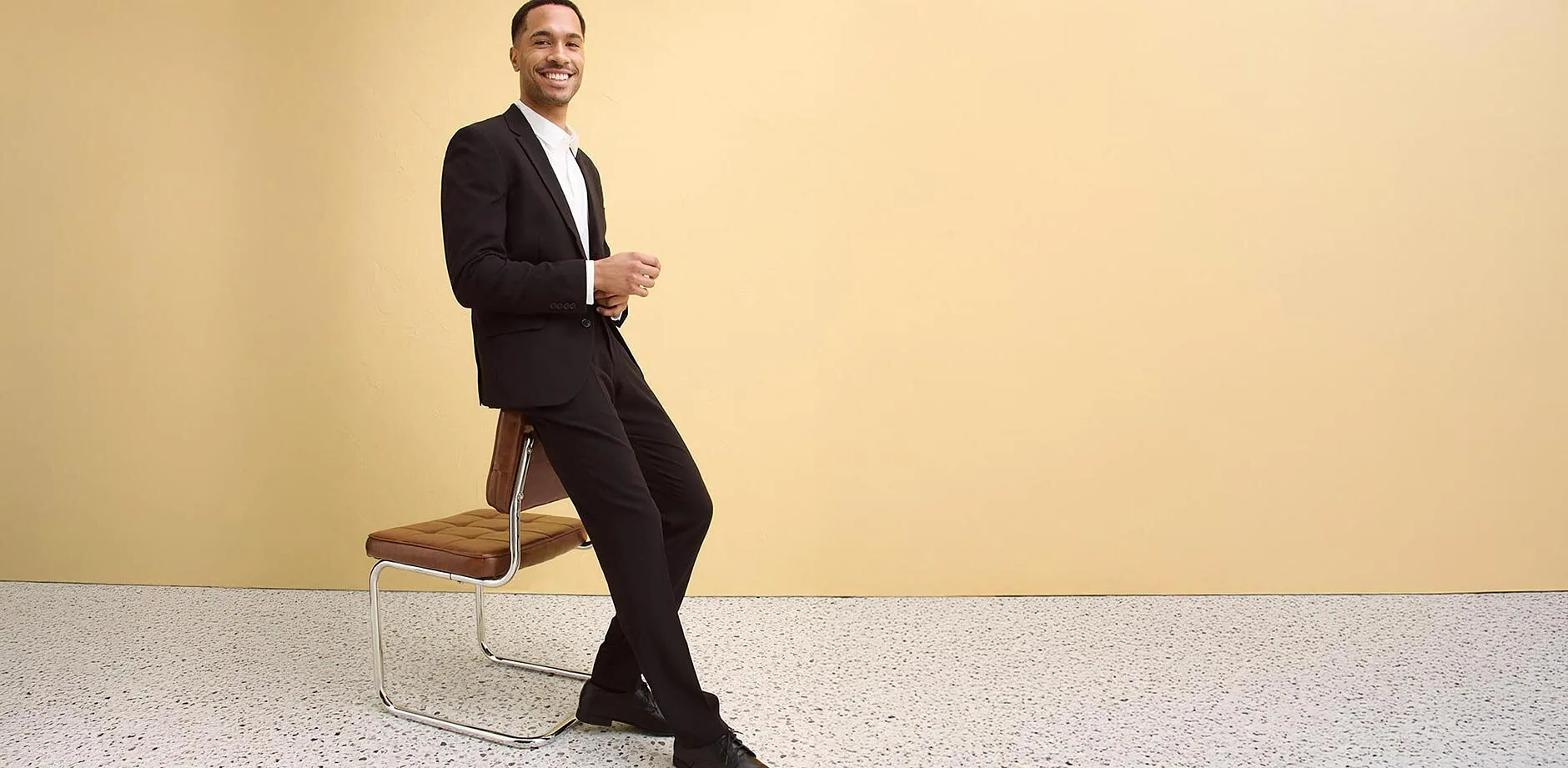 Elegant svart kostym med vit skjorta, perfekt kombinerat med passande skor.

