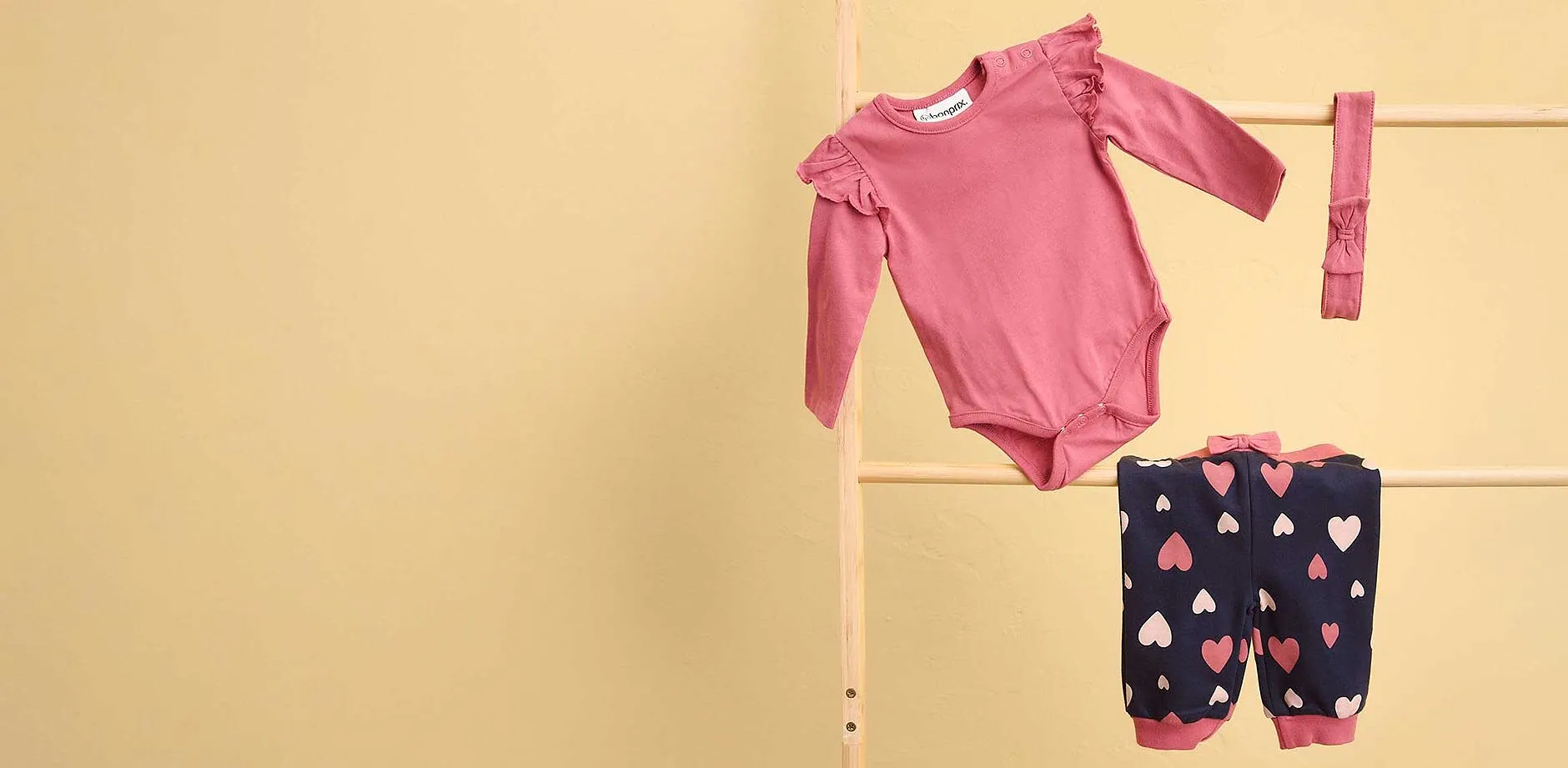 S&ouml;tt babyset: Rosa body och m&ouml;rkbl&aring; byxor med hj&auml;rtm&ouml;nster.