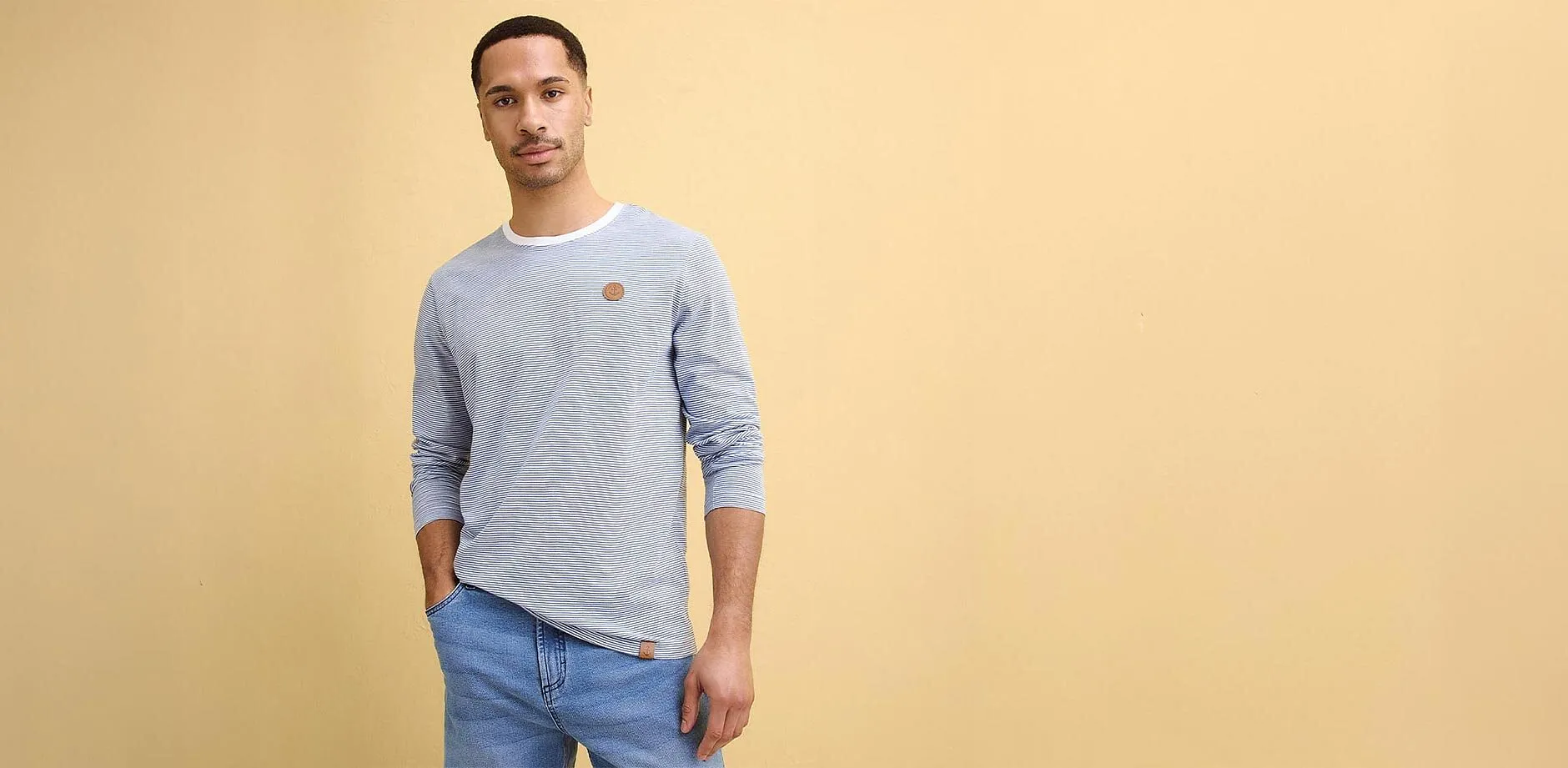 Ljusbl&aring; l&aring;ng&auml;rmad tr&ouml;ja och jeans. 
