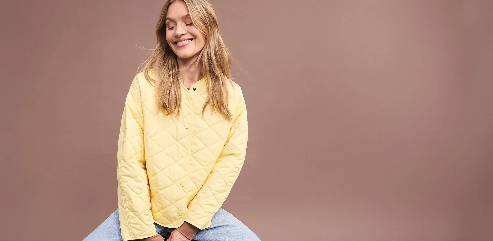 Gul qulitad jacka i oversizemodell kombinerad med bl&aring; byxor.