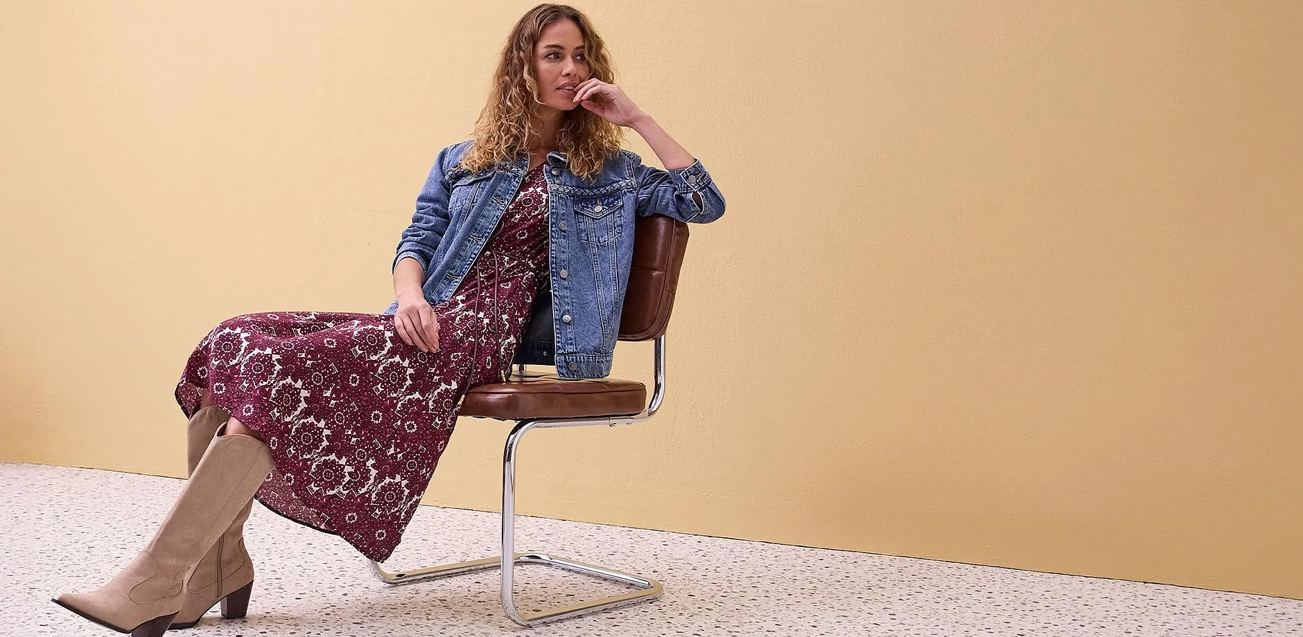 Jeansjacka &ouml;ver blommig maxikl&auml;nning, kombinerat med beiga st&ouml;vlar.

