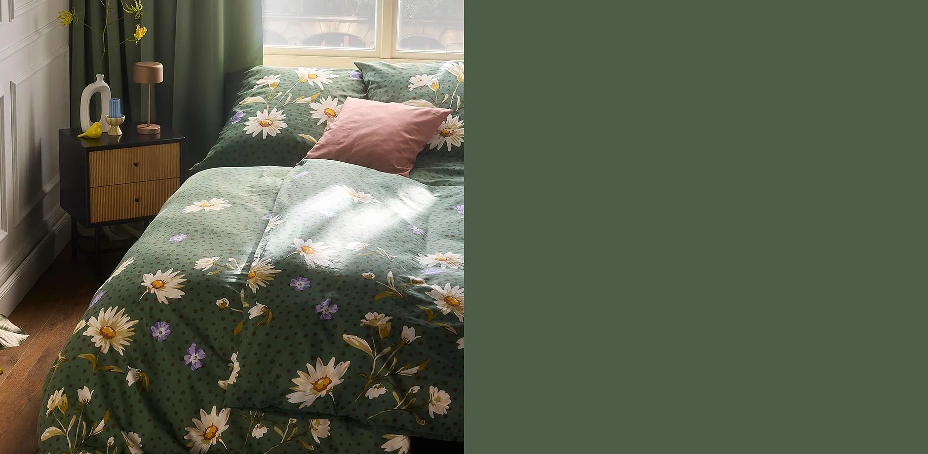 Blommig s&auml;nglinne i gr&ouml;nt pryder s&auml;ngen, kompletterad med passande kuddar.

