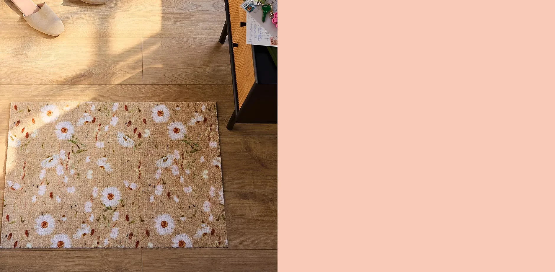 Bekv&auml;ma tofflor p&aring; tr&auml;golv bredvid blommig d&ouml;rrmatta.

